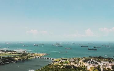 Aerial shot of ships and buildings near ocean in Singapore