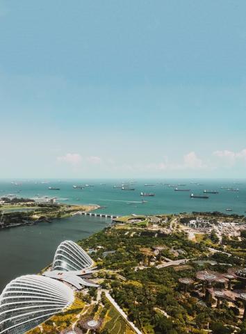 Aerial shot of ships and buildings near ocean in Singapore